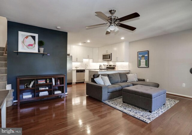 living room featuring recessed lighting, a ceiling fan, dark wood finished floors, and baseboards