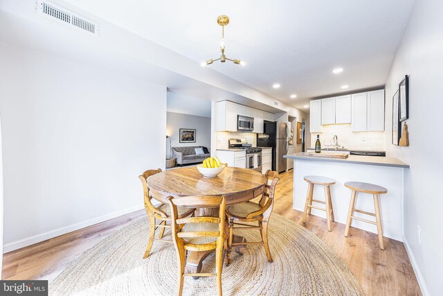 dining space featuring baseboards, recessed lighting, and light wood-type flooring