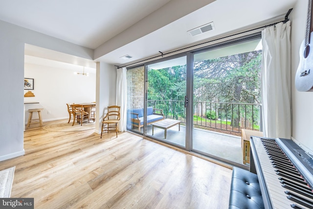 living area featuring wood finished floors, baseboards, and a chandelier