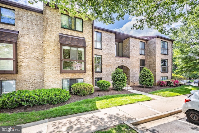 view of front of property with brick siding and uncovered parking
