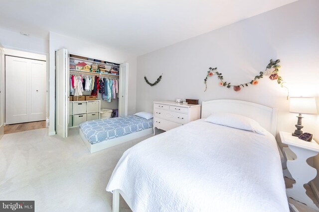 bedroom featuring light carpet and a closet
