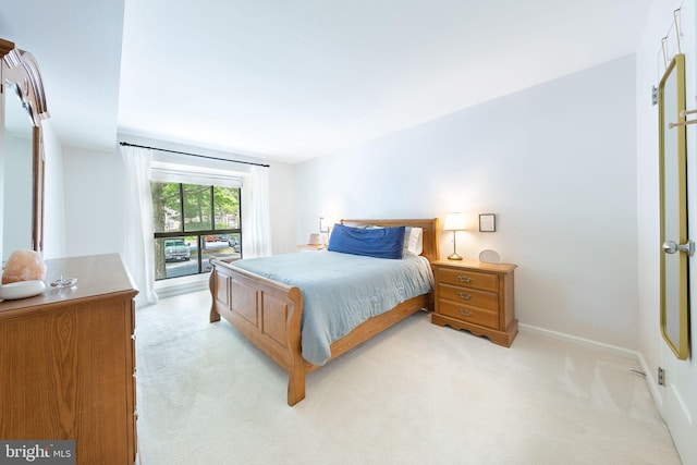 bedroom with light carpet and baseboards