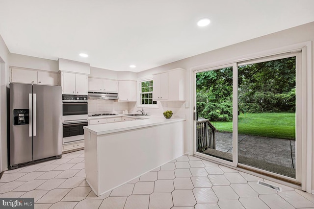 205 Dunbeath Ct, Lutherville Timonium, MD 21093 - kitchen with stainless steel fridge with ice dispenser, under cabinet range hood, a sink, double oven, and a peninsula