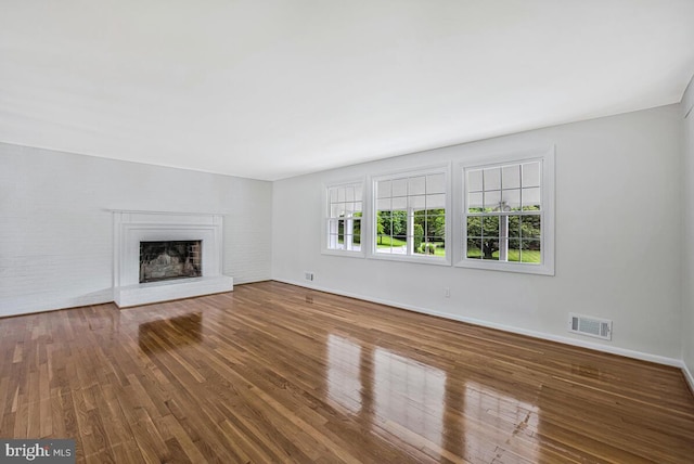 205 Dunbeath Ct, Lutherville Timonium, MD 21093 - unfurnished living room featuring wood finished floors, a fireplace with raised hearth, and baseboards