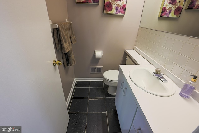 half bathroom with visible vents, vanity, baseboards, tile patterned floors, and toilet