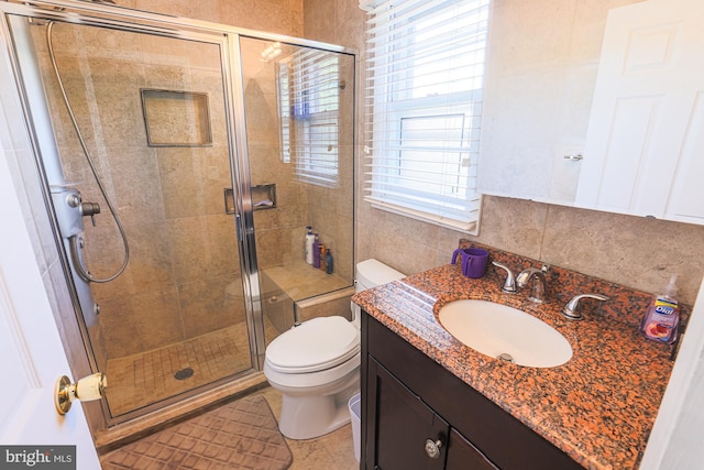 bathroom with vanity, a stall shower, and toilet