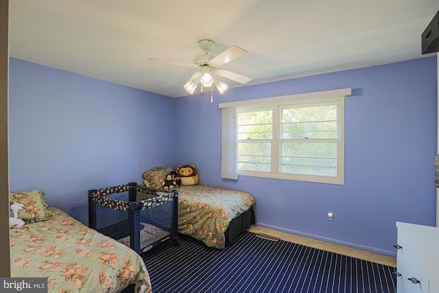 carpeted bedroom with baseboards and a ceiling fan