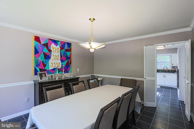 dining area with baseboards, ornamental molding, and dark tile patterned flooring