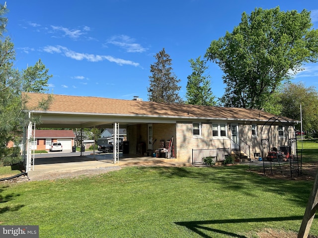 back of house featuring a lawn, fence, a carport, and driveway