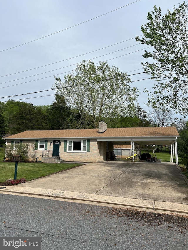 view of front of home with a chimney, a front yard, and concrete driveway