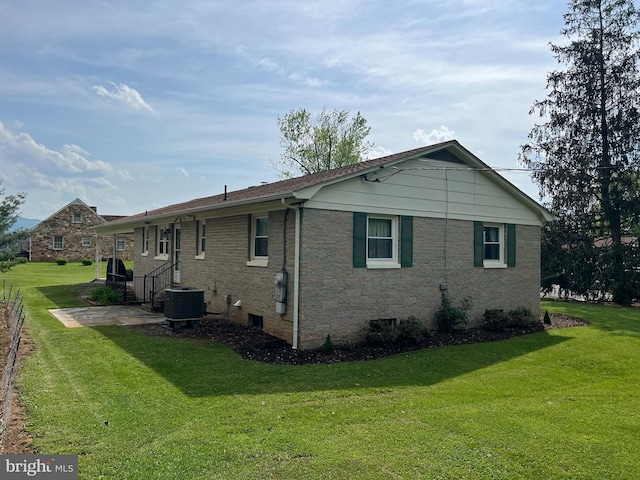 rear view of property featuring central AC unit and a yard