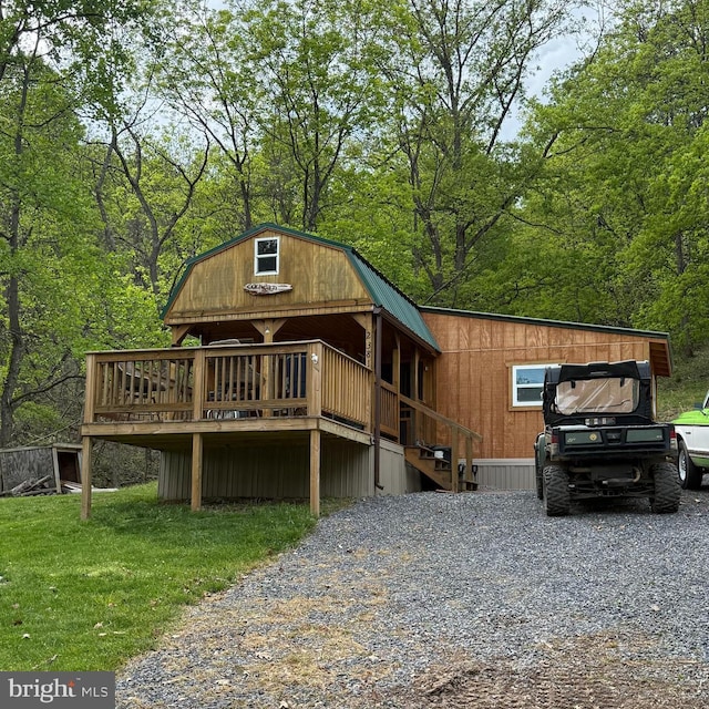 view of front of house featuring a wooden deck and a gambrel roof