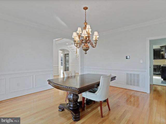 191 Inez Ln, Stephens City, VA 22655 - dining area with visible vents, ornamental molding, an inviting chandelier, arched walkways, and light wood-style flooring