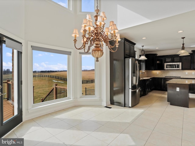 191 Inez Ln, Stephens City, VA 22655 - kitchen featuring light stone countertops, appliances with stainless steel finishes, an inviting chandelier, dark cabinets, and light tile patterned floors