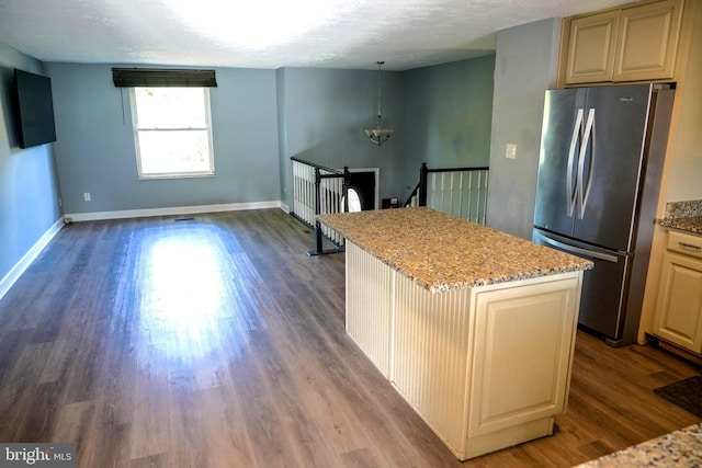 7918 Royal Mint Pl, Pasadena, MD 21122 - kitchen with a center island, wood finished floors, freestanding refrigerator, baseboards, and light stone counters