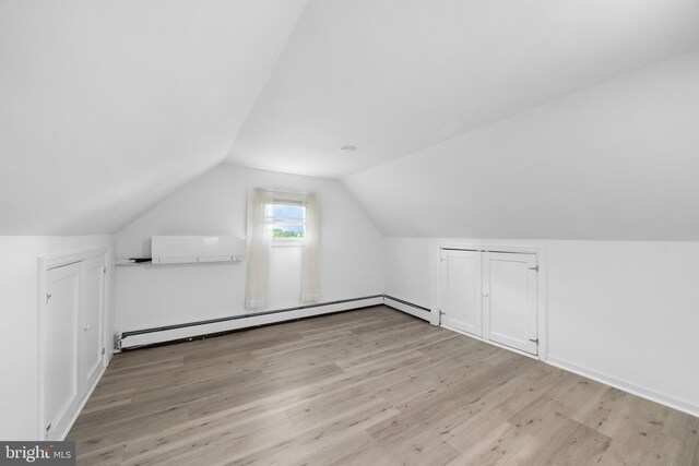 1504 Montgomery Rd, Wilmington, DE 19805 - additional living space with a wall unit AC, vaulted ceiling, a baseboard heating unit, and wood finished floors
