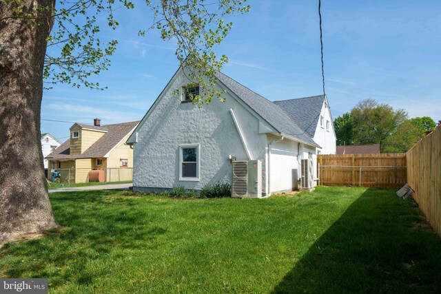 1504 Montgomery Rd, Wilmington, DE 19805 - rear view of house featuring a lawn, stucco siding, fence private yard, and roof with shingles