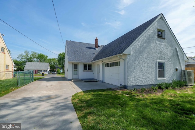 1504 Montgomery Rd, Wilmington, DE 19805 - exterior space with a garage, central AC, fence, stucco siding, and a chimney