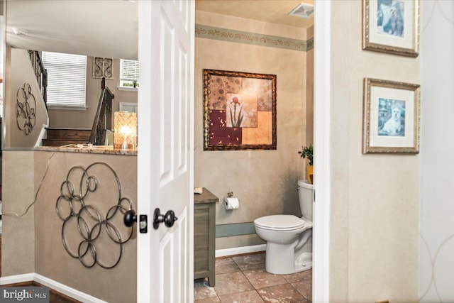 bathroom with toilet, baseboards, and visible vents