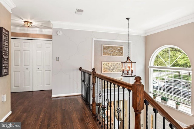 corridor with a notable chandelier, baseboards, an upstairs landing, wood finished floors, and visible vents