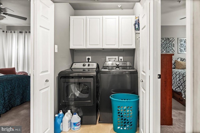 clothes washing area featuring separate washer and dryer, cabinet space, and ceiling fan
