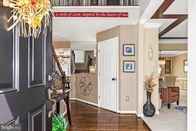 foyer entrance with baseboards, ornamental molding, stairs, and wood finished floors