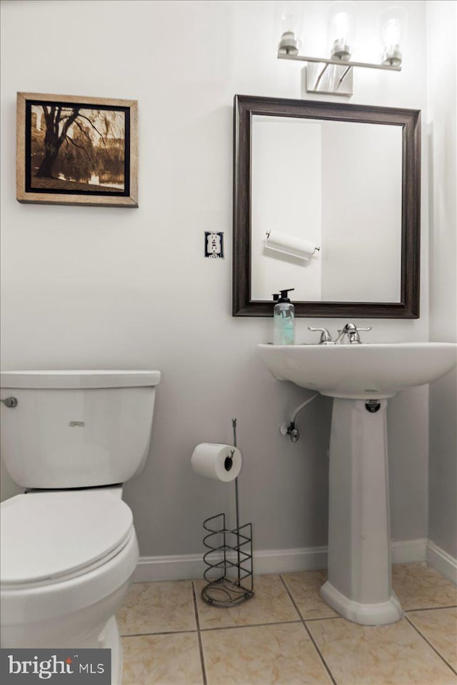 bathroom featuring toilet, baseboards, and tile patterned flooring