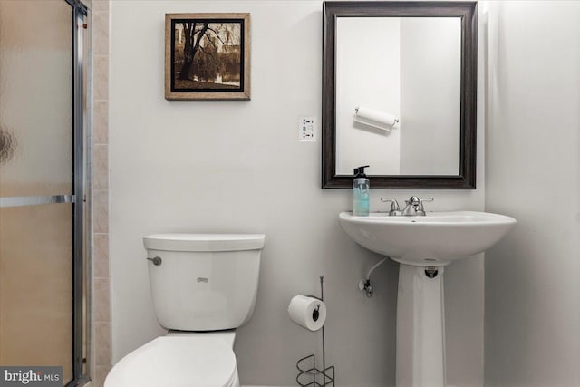 full bath with a shower with door and toilet