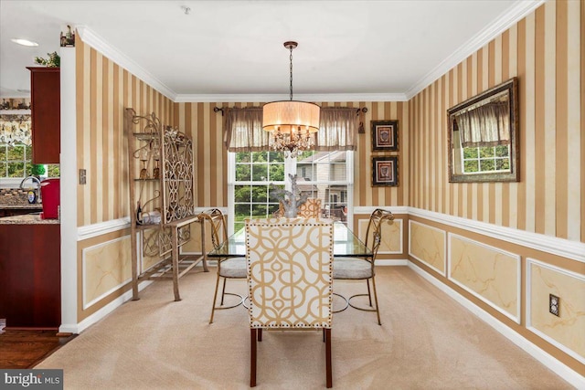 dining room with an inviting chandelier, a healthy amount of sunlight, wallpapered walls, and light colored carpet