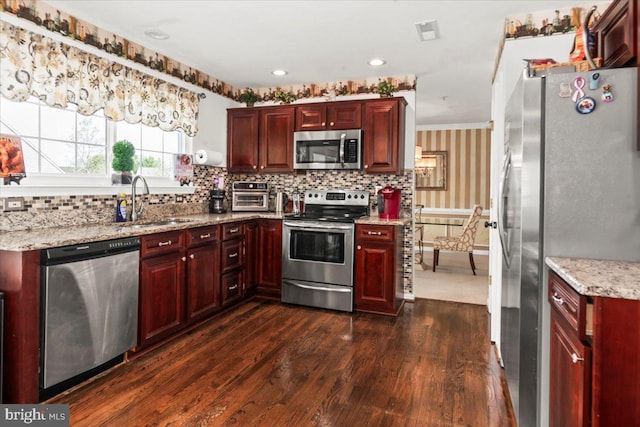 kitchen featuring stainless steel appliances, a sink, and reddish brown cabinets
