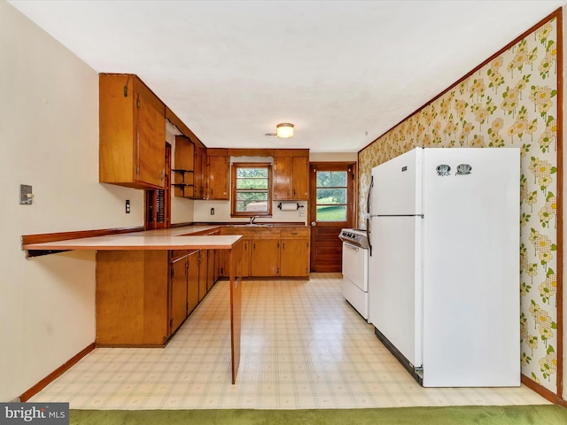9618 Hall Rd, Frederick, MD 21701 - kitchen featuring white appliances, wallpapered walls, brown cabinetry, baseboards, and a peninsula