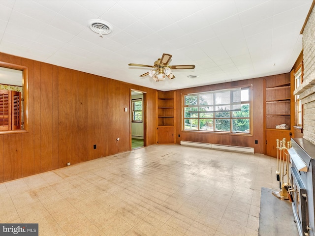 9618 Hall Rd, Frederick, MD 21701 - unfurnished living room with baseboard heating, built in shelves, wood walls, a fireplace, and ceiling fan