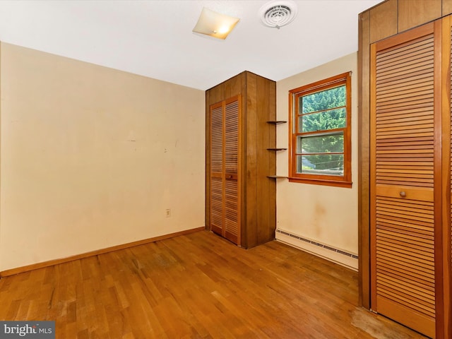 9618 Hall Rd, Frederick, MD 21701 - unfurnished bedroom with baseboard heating, wood finished floors, and baseboards