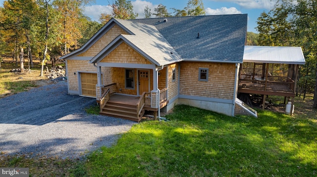view of front of home with a porch, a shingled roof, a front lawn, and a deck