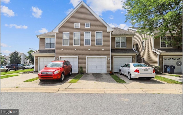 view of property featuring an attached garage, driveway, and roof with shingles