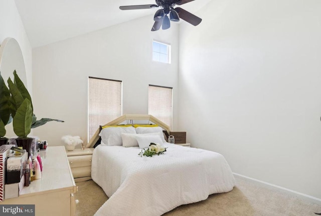 bedroom featuring light colored carpet, a ceiling fan, baseboards, and high vaulted ceiling