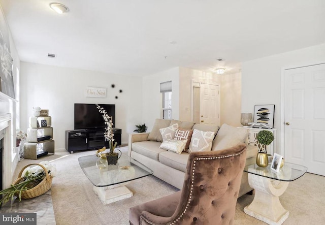 living room featuring carpet flooring, visible vents, and a fireplace