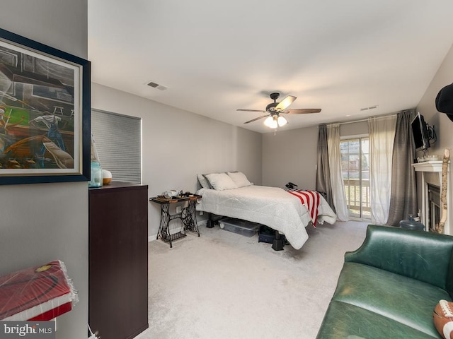 carpeted bedroom featuring access to outside, ceiling fan, visible vents, and a fireplace