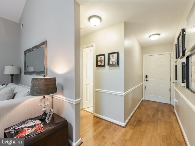 hallway with baseboards and light wood-style flooring