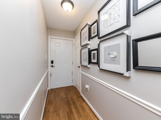 doorway to outside with baseboards and wood finished floors
