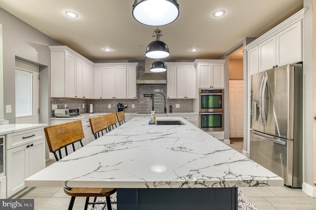 7140 Barry Rd, Alexandria, VA 22315 - kitchen with stainless steel appliances, wall chimney exhaust hood, tasteful backsplash, a kitchen breakfast bar, and recessed lighting