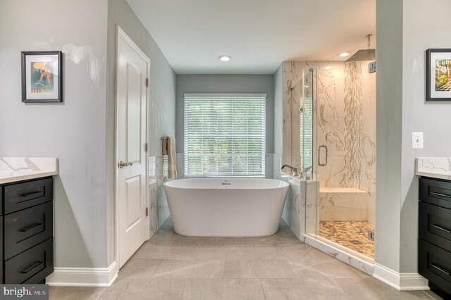 7140 Barry Rd, Alexandria, VA 22315 - bathroom featuring vanity, a marble finish shower, a freestanding tub, and baseboards