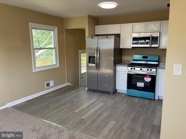 9016 Samoset Rd, Randallstown, MD 21133 - kitchen with visible vents, baseboards, white cabinetry, light wood-style flooring, and stainless steel appliances