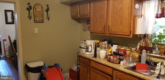 kitchen featuring brown cabinetry, a sink, and light countertops