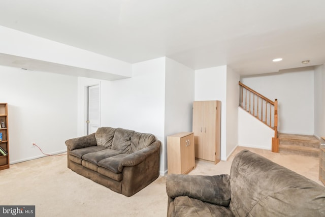 living area featuring light colored carpet, stairs, and baseboards