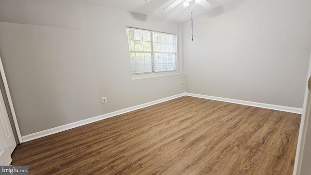 spare room with baseboards, a ceiling fan, and wood finished floors