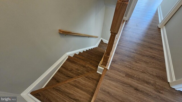 staircase with baseboards and wood finished floors