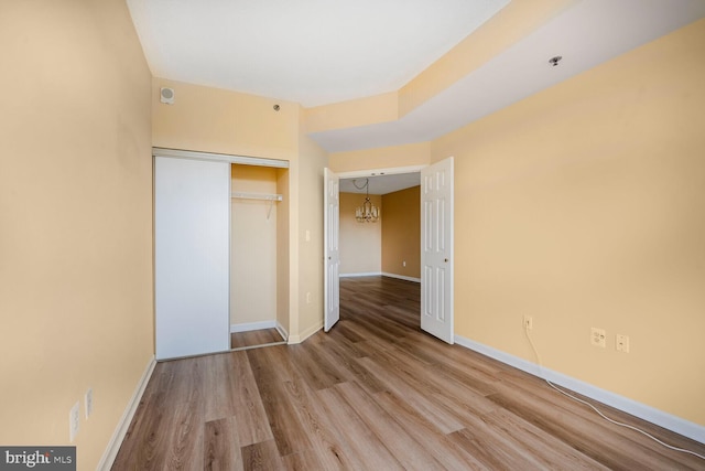 3200 N Leisure World Blvd Unit 1010, Silver Spring, MD 20906 - unfurnished bedroom with a chandelier, wood finished floors, a closet, and baseboards