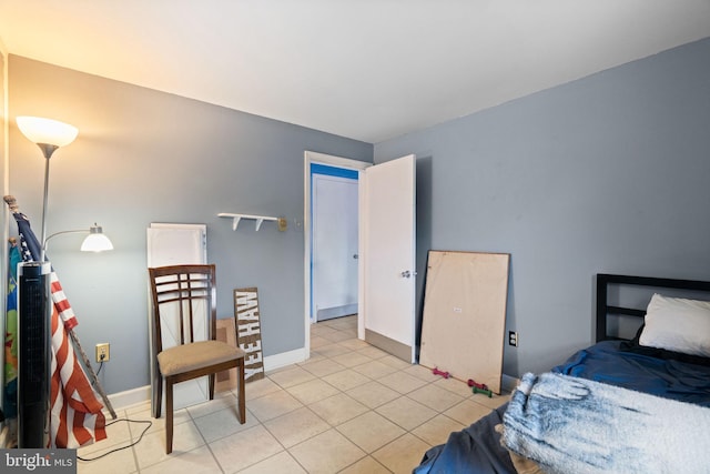 bedroom featuring light tile patterned floors and baseboards