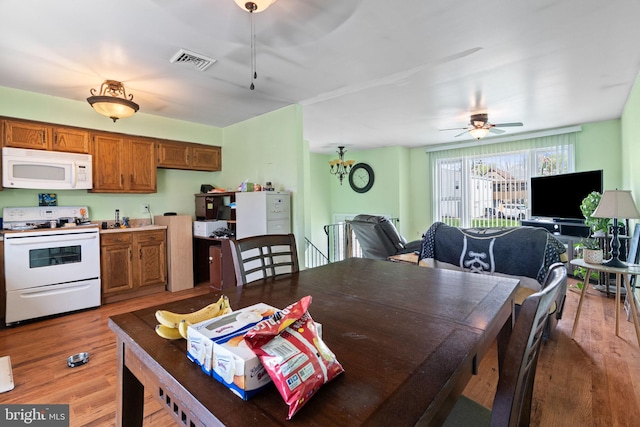 dining space featuring ceiling fan, visible vents, and light wood-type flooring